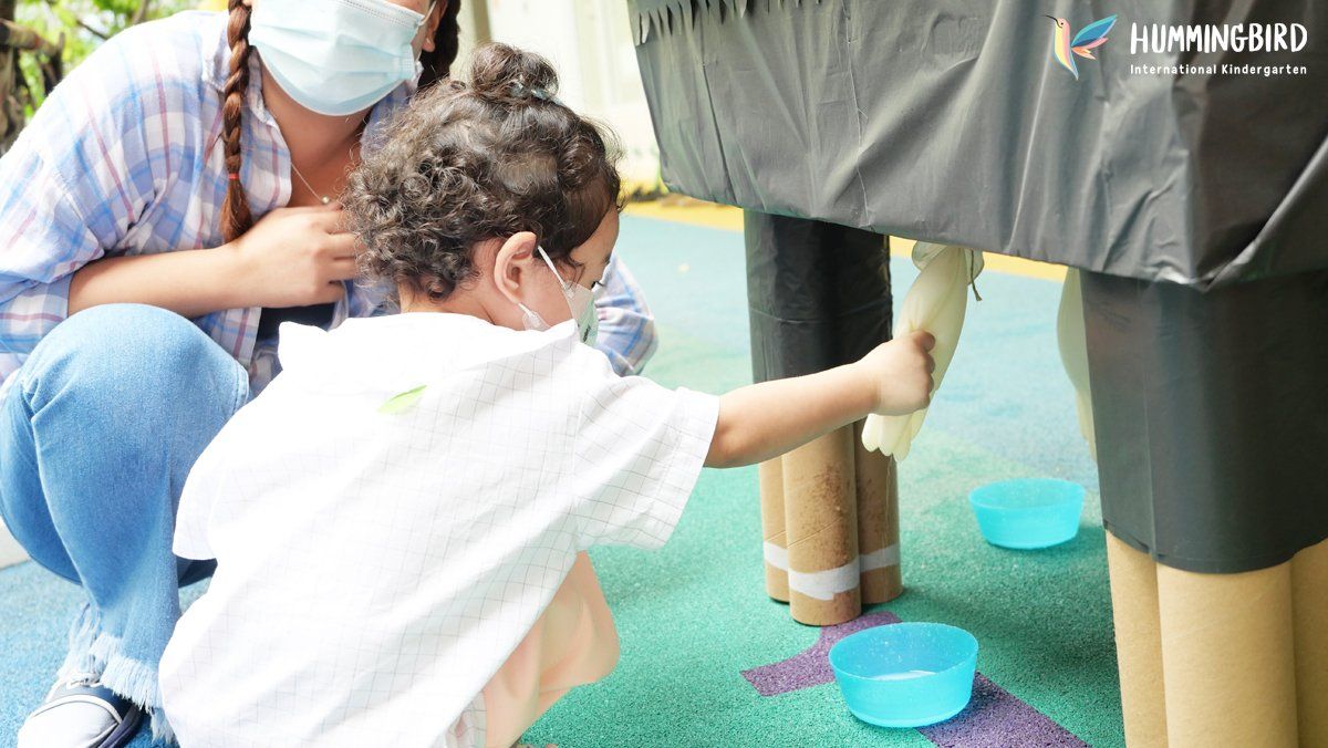 A woman is kneeling next to a child wearing a mask.