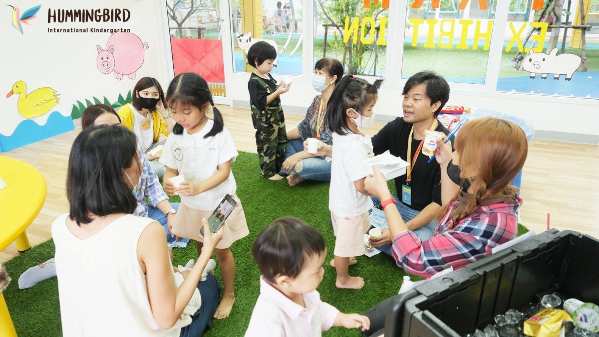 A group of people are sitting on the floor eating ice cream.