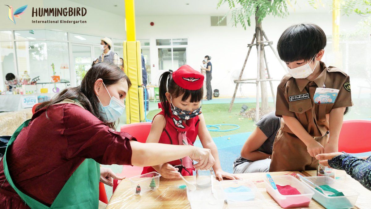 A woman and two children are sitting at a table wearing masks.
