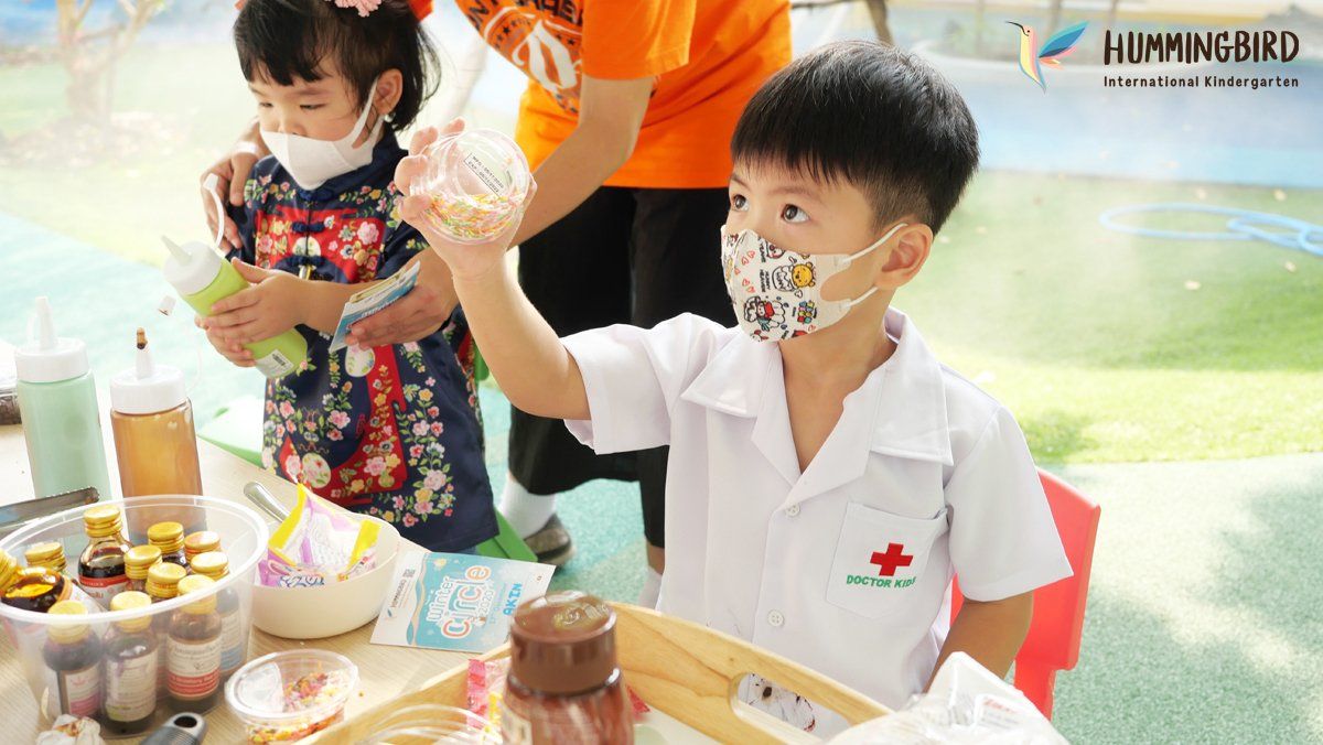 A boy and a girl wearing masks are sitting at a table.
