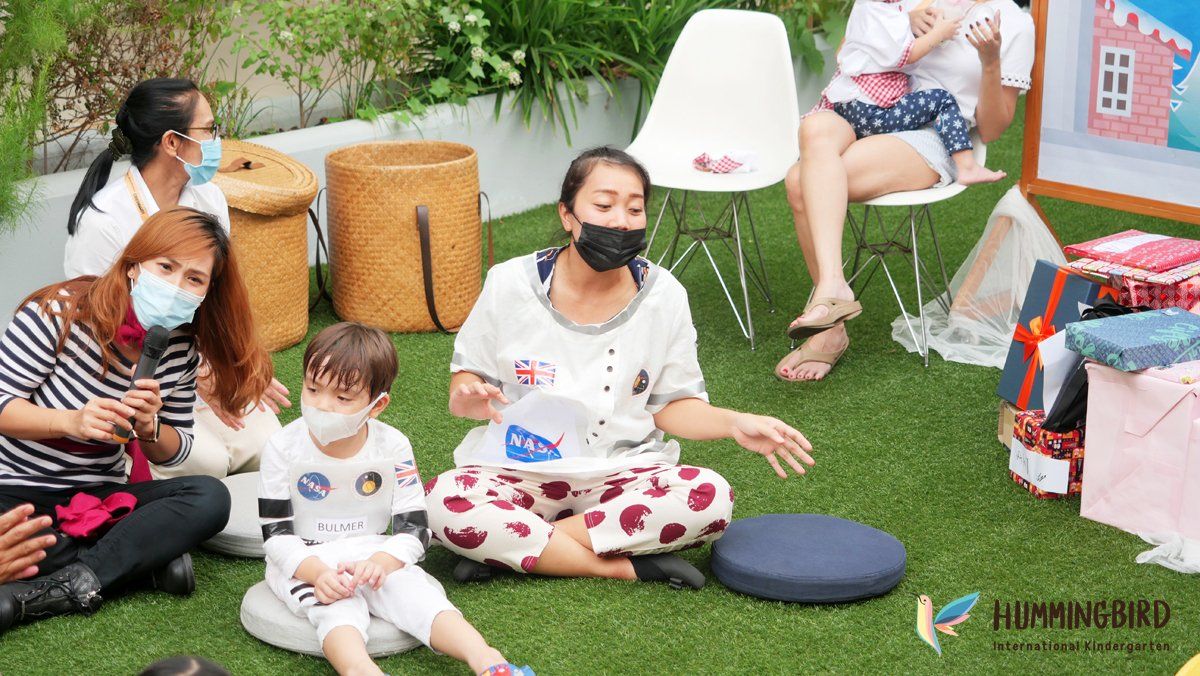 A group of people wearing masks are sitting on the grass.