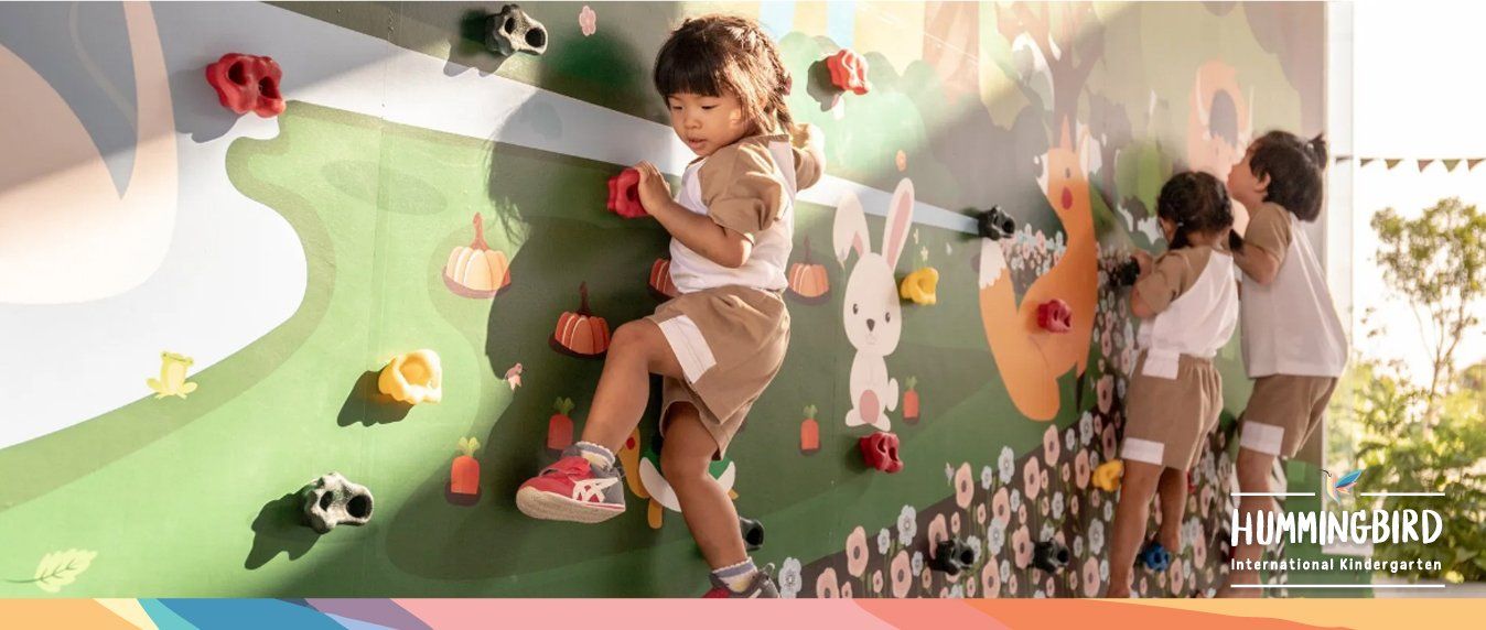 A group of children are climbing a climbing wall.