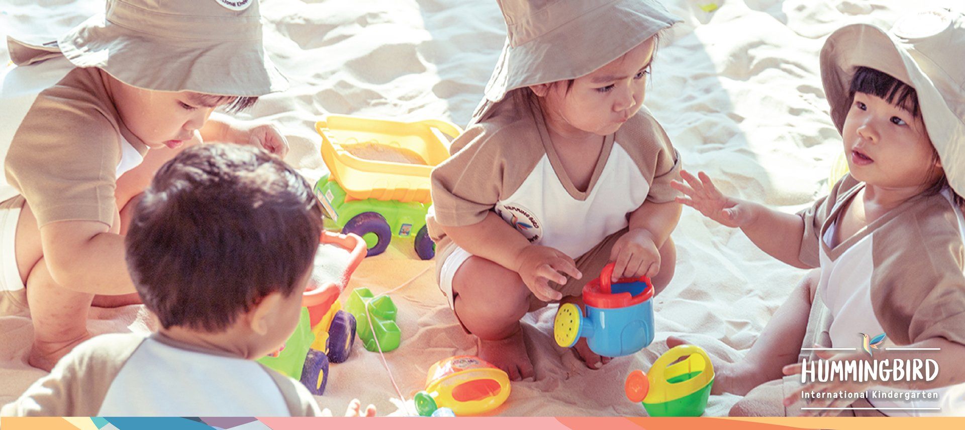 A group of young children are playing in the sand on the beach.