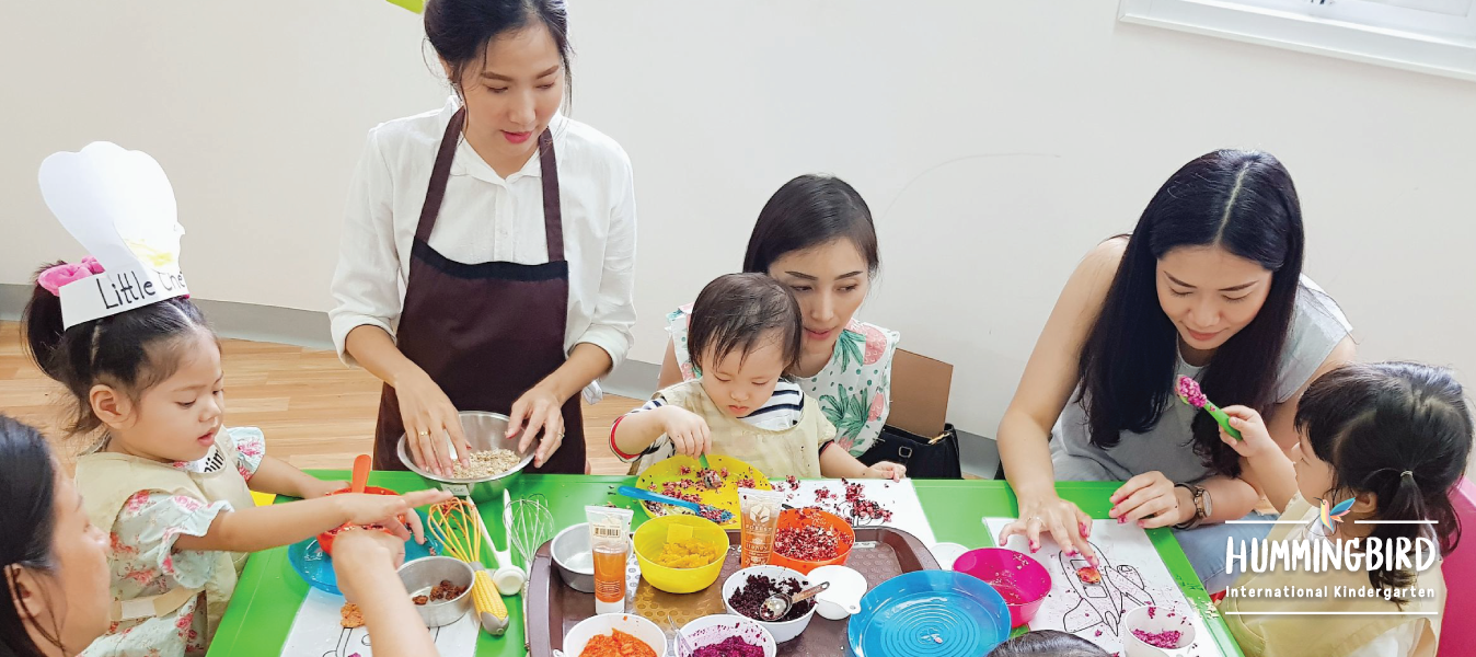 A group of women and children are sitting around a table.