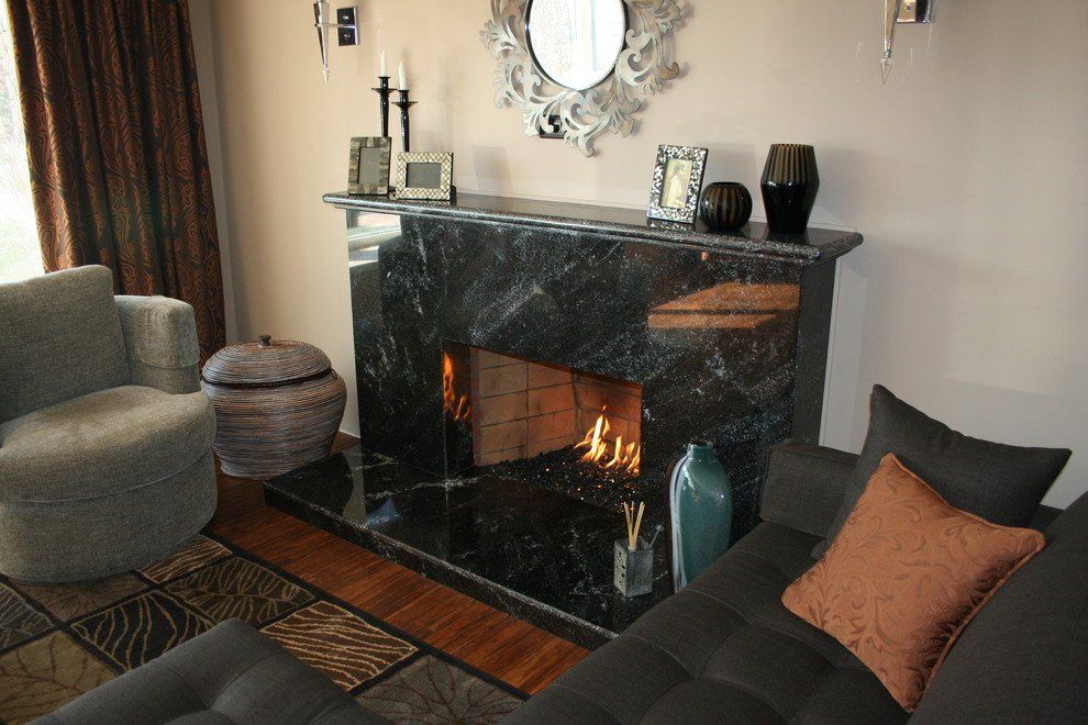 A living room with a black quartz fireplace and a couch.