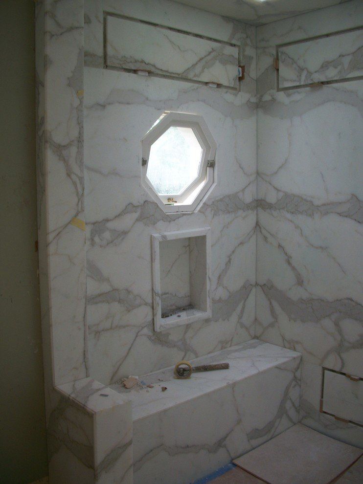 A bathroom with marble walls and a window.
