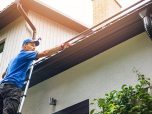 Expert Gutter Cleaners — Man Cleaning A Gutter In Mount Holly, NC Expert Gutter Cleaners — Man Cleaning A Gutter In Mount Holly, NC
