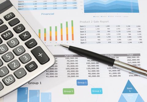 Calculator, pen, papers with charts