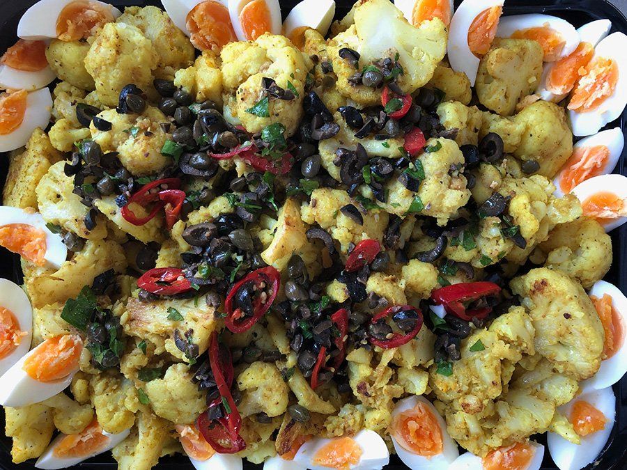 A close up of a plate of food with eggs and cauliflower