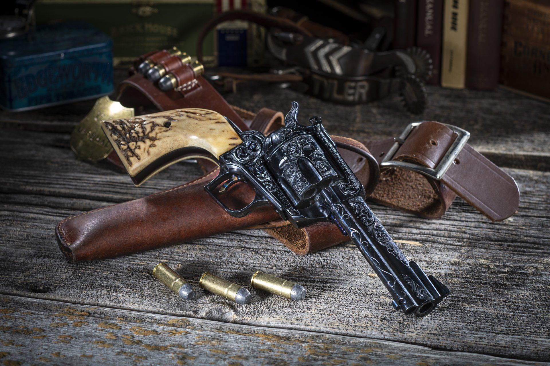 A vintage revolver, holster, and bullets on a rustic wooden surface.