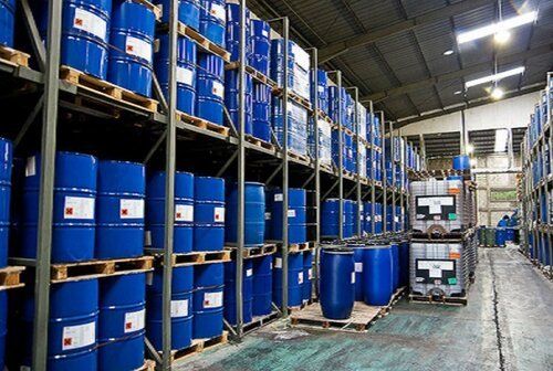 Estantes de almacén llenos de barriles azules de productos químicos industriales.