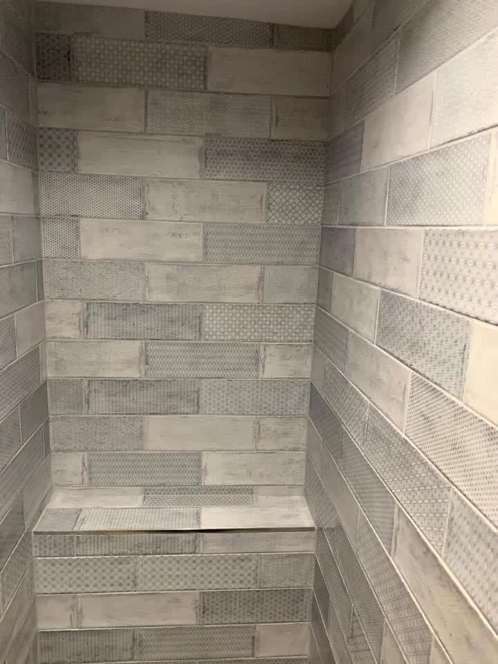 Narrow grey tiled bathroom enclosure