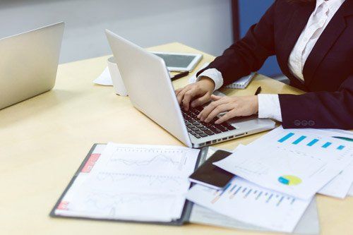 donna scrive sulla tastiera di un portatile su una scrivania