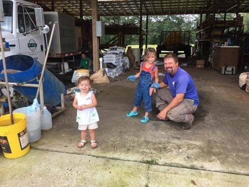 Man with two kids in storage area. 
