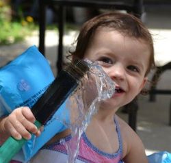 child interacting with water from a hose child interacting with water from a hose