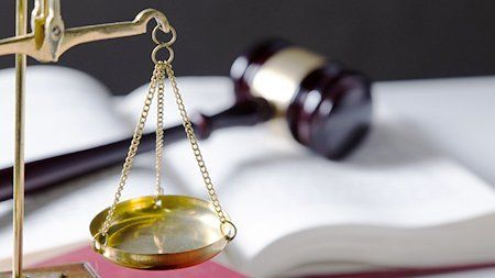 R J Cole and Partners scale of justice scale of justice and gavel on top of an open book