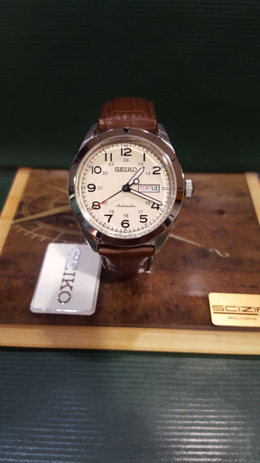 Orologio Seiko con cinturino in pelle marrone esposto su una superficie di legno con etichetta Seiko.