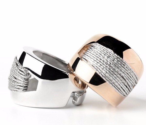 Due anelli, uno in argento e uno in oro rosa, con dettaglio di fascia intrecciata in argento.