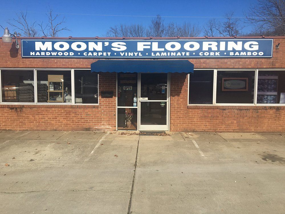 A brick building with a sign that says moon 's flooring