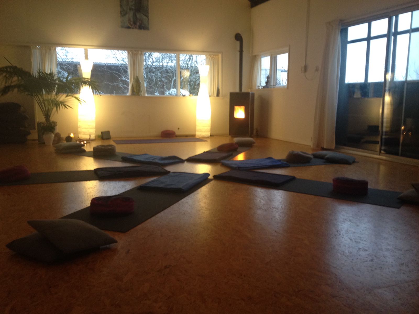 De matten liggen in een cirkel voor de zwangerschapsyoga met in de achtergrond de palletkachel aan.