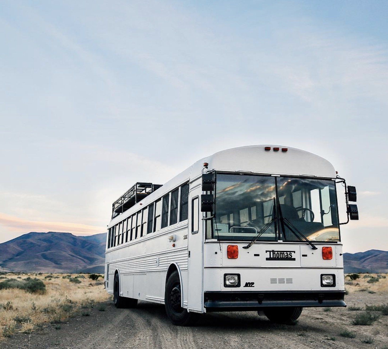 The skoolie bus by Debbie & Gabriel Mayes sits parked in the desert as an example of one of the three ways to grow your business with us.