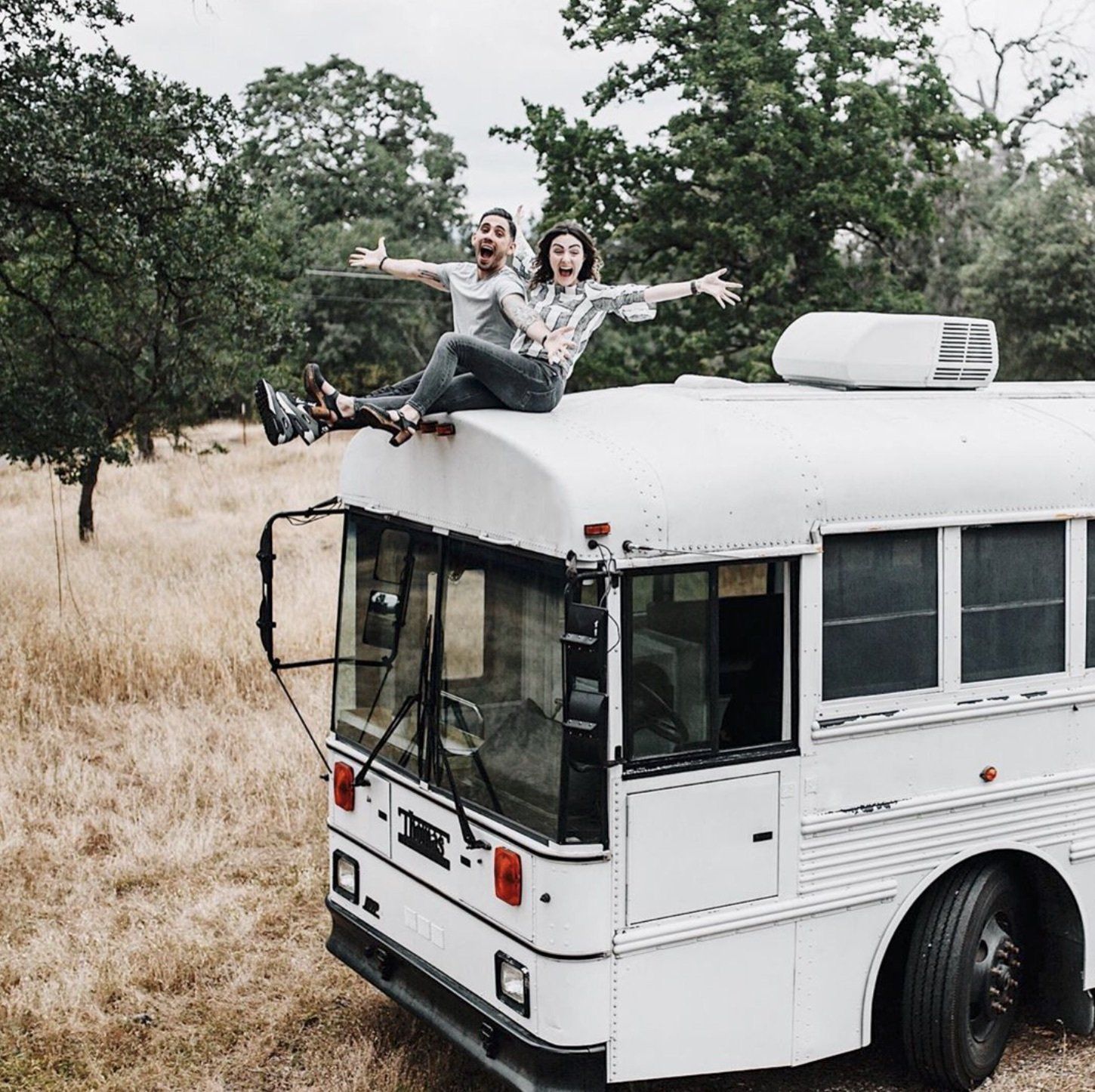 Debbie and Gabriel Mayes sit on top of their skoolie and are excited about their great American road trip.