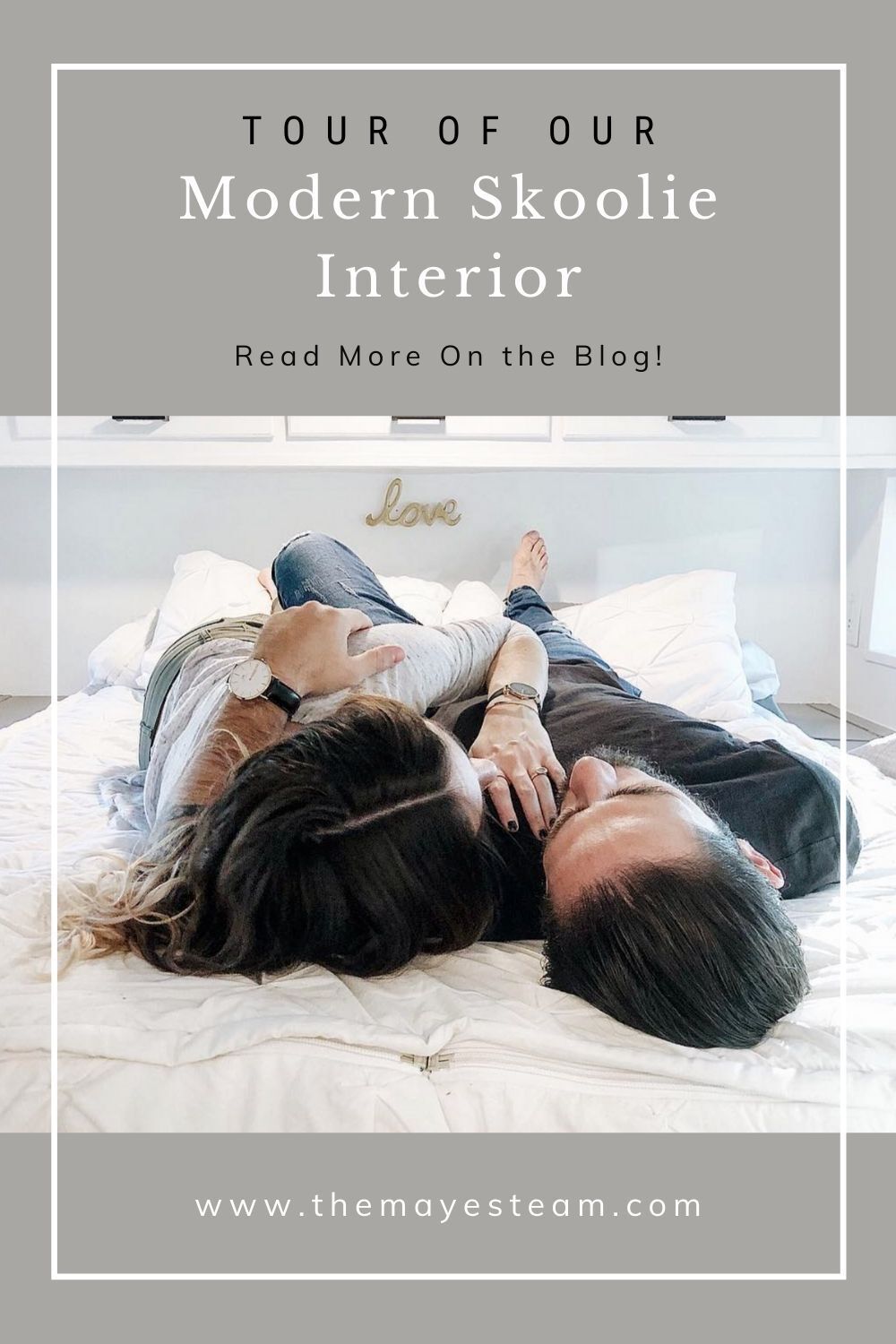 Debbie and Gabriel Mayes cuddle on their bed, image overlaid with text that reads Tour of Our Modern Skoolie Interior Read More on the Blog!