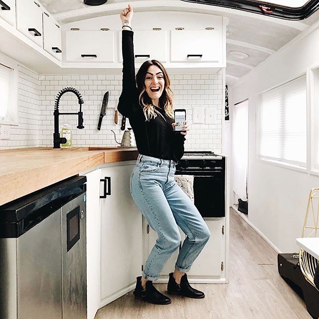 Debbie Mayes celebrates school bus conversion cost in the kitchen of her skoolie bus