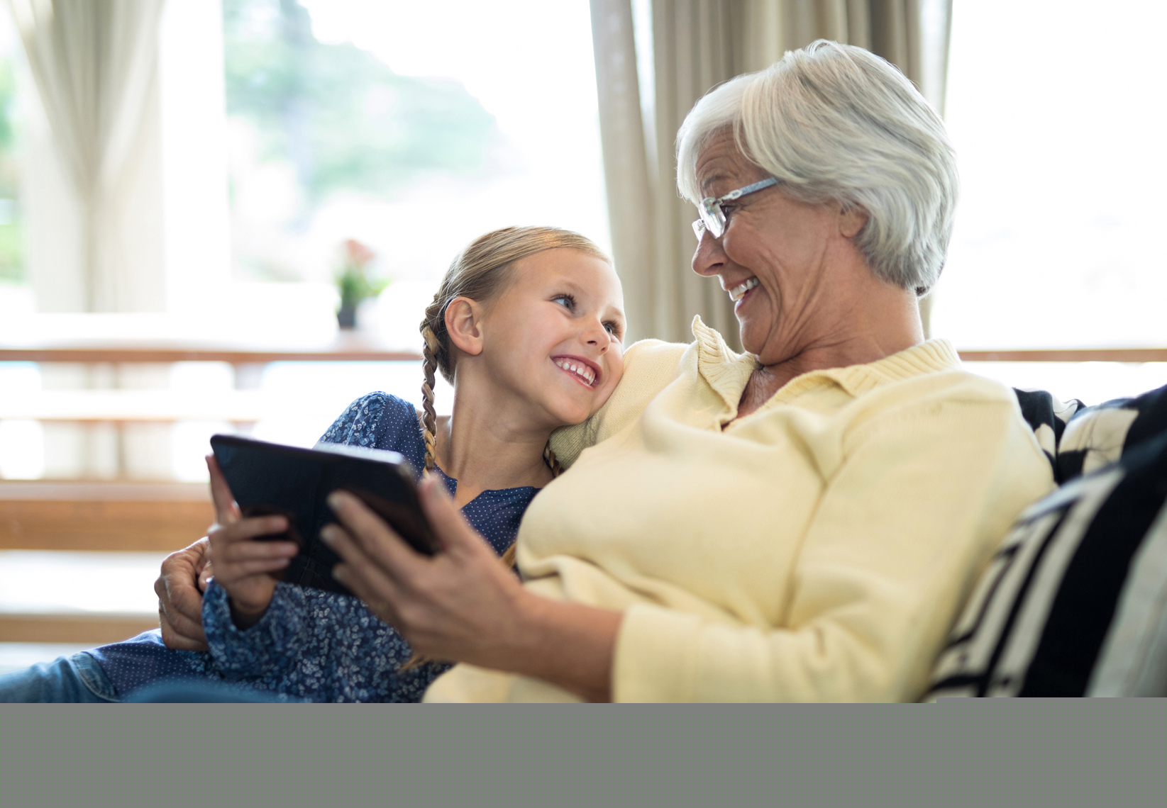 In-Home Care — Smiling Granddaughter And Grandmother Using Digital Tablet In Spring, MD In-Home Care — Smiling Granddaughter And Grandmother Using Digital Tablet In Spring, MD