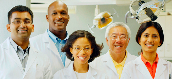 A group of doctors are posing for a picture in a dental office