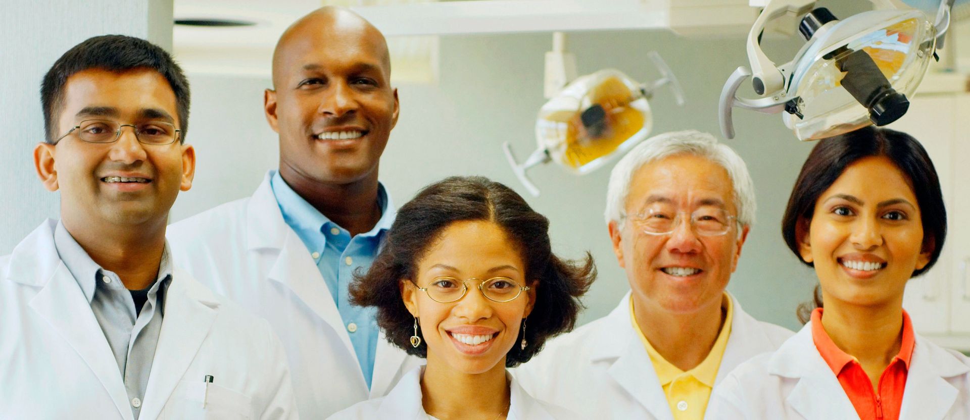A group of dentists are posing for a picture in a dental office.