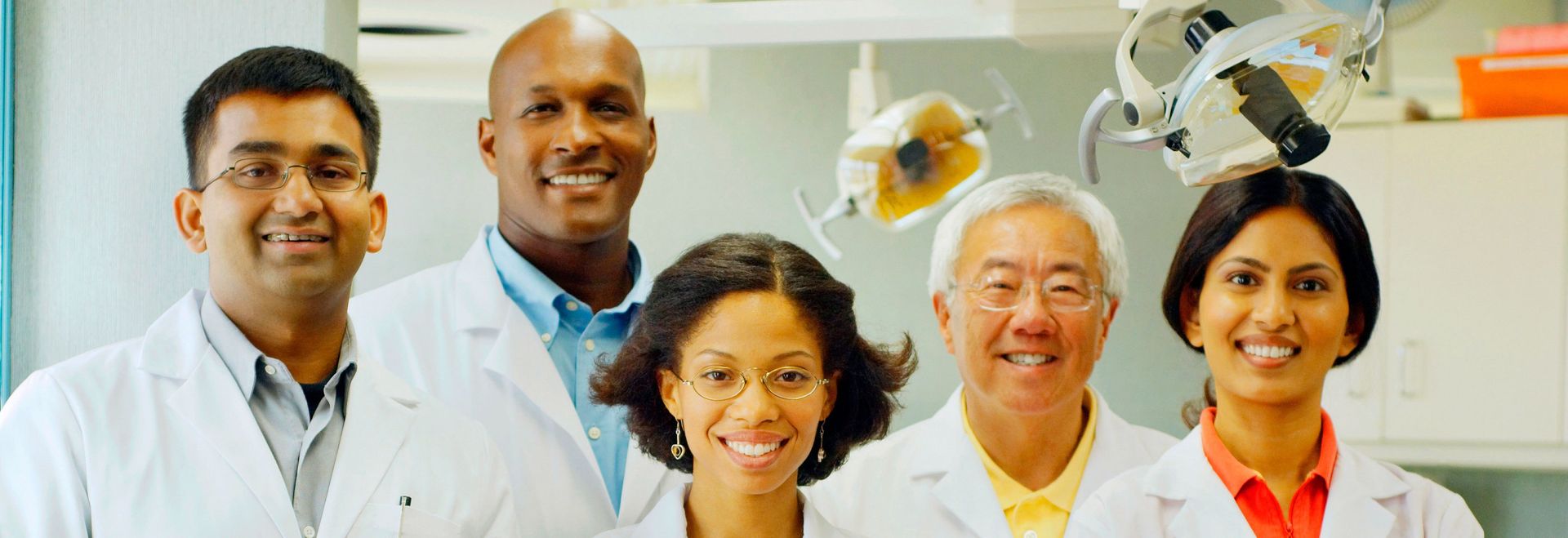 A group of dentists are posing for a picture in a dental office.
