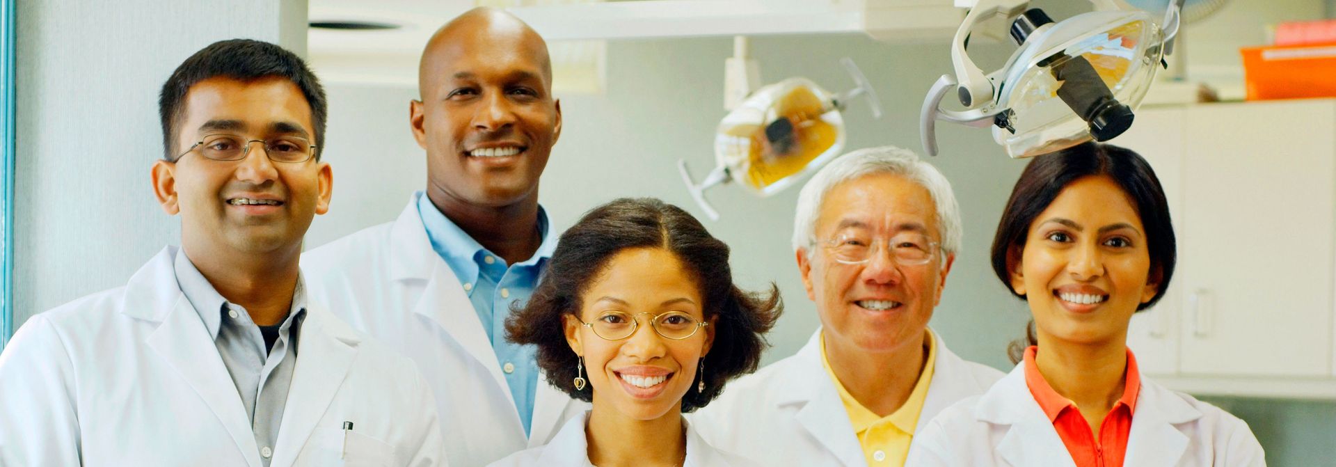 A group of dentists are posing for a picture in a dental office.