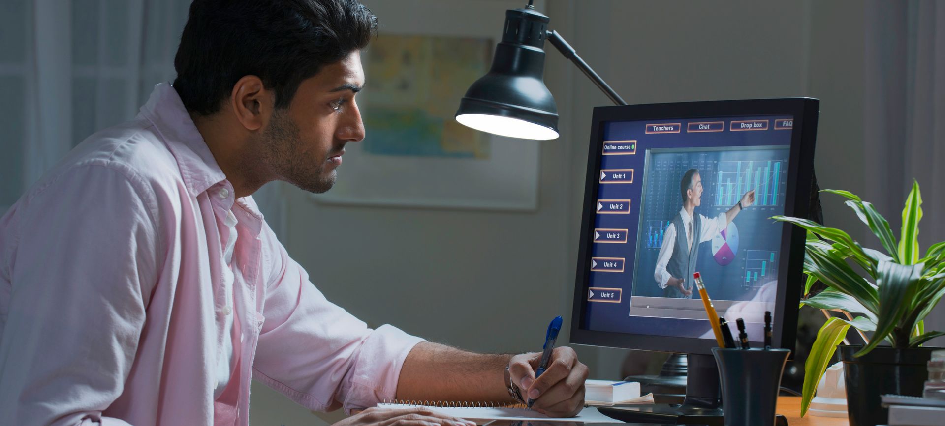 A man is sitting at a desk in front of a computer.