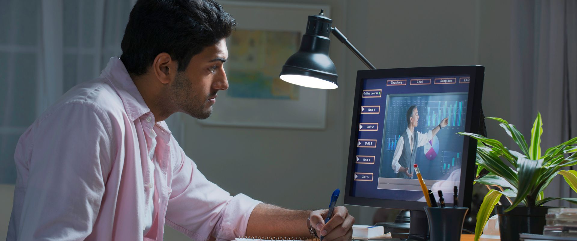 A man is sitting at a desk in front of a computer.