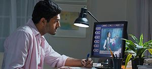 A man is sitting at a desk in front of a computer.