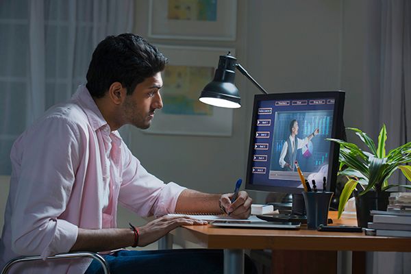 A man is sitting at a desk in front of a computer.