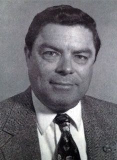 A black and white photo of a man in a suit and tie