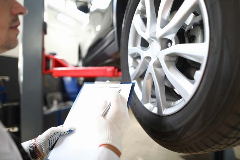 Man Checking Vehicle Tires — Columbiana, AL — Howard Tire Service, Towing and Recovery Man Checking Vehicle Tires — Columbiana, AL — Howard Tire Service, Towing and Recovery