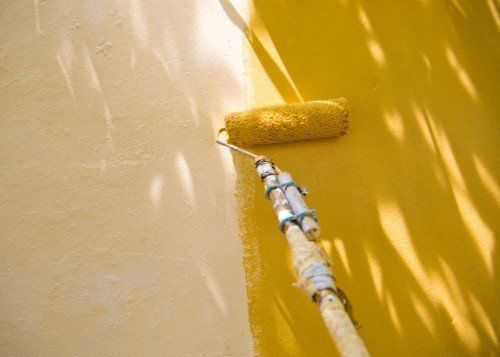 rullo per pitturare che sta riverniciando il muro