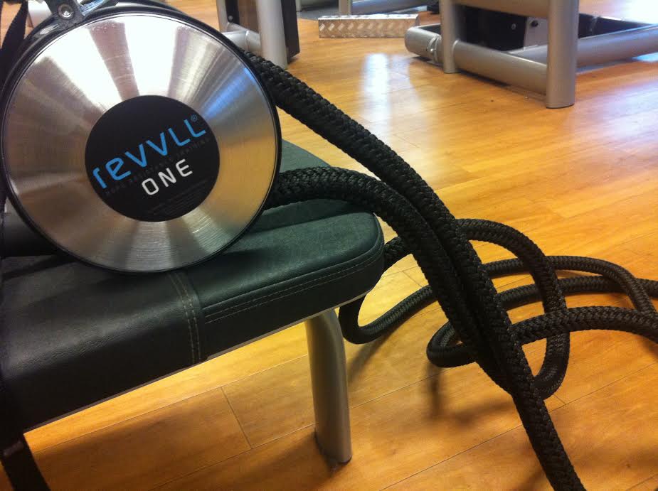 Black braided cord attached to a metallic vacuum head resting on a chair on a wooden floor