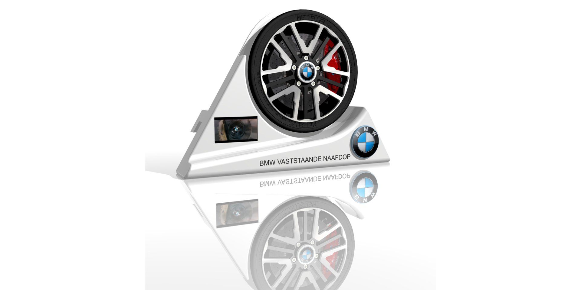 White display stand holding a black alloy car wheel with red/blue logo, shown with a reflection on white background