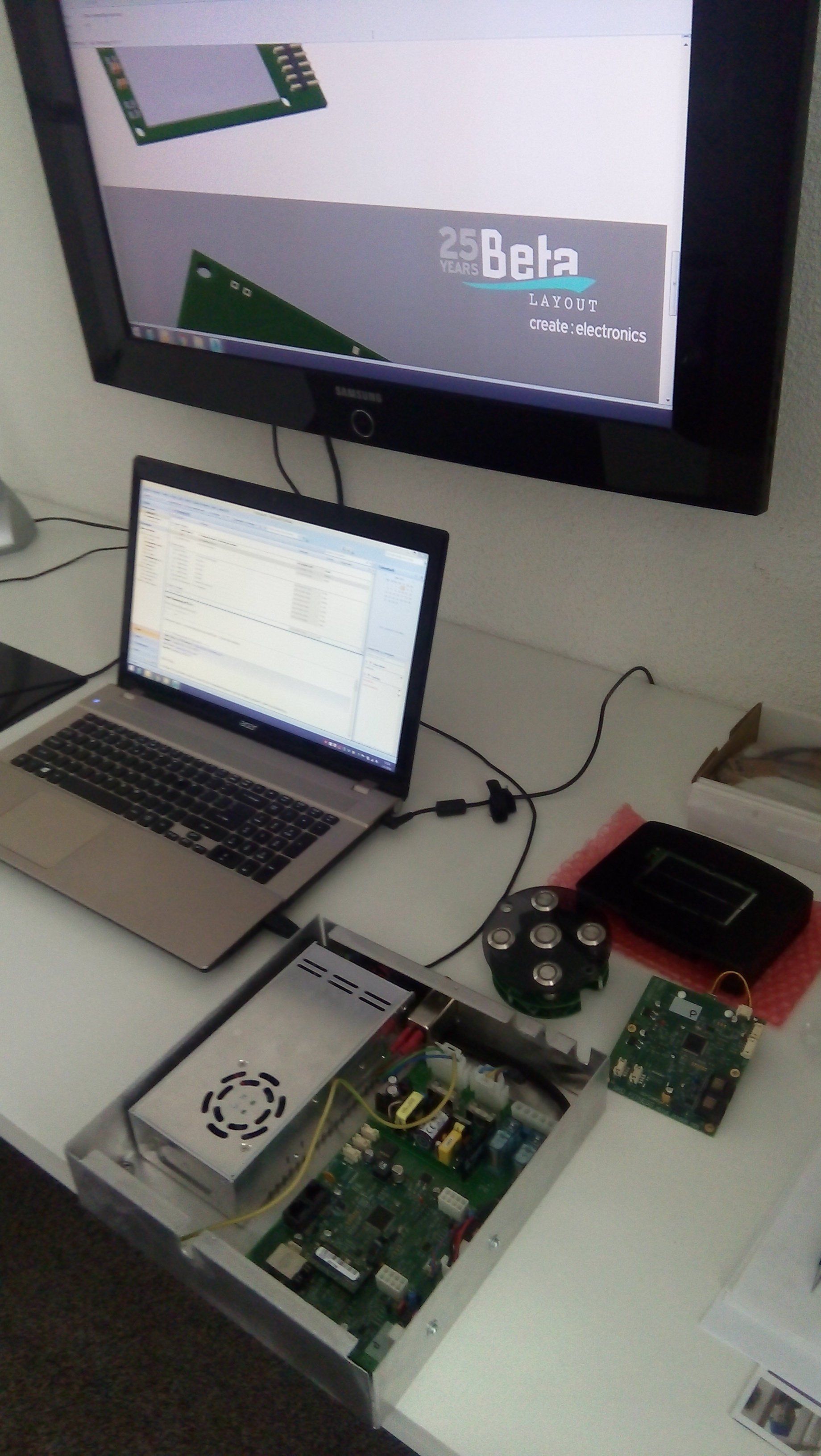 Laptop connected to electronics hardware on a desk, with a monitor showing “Beta” above it.