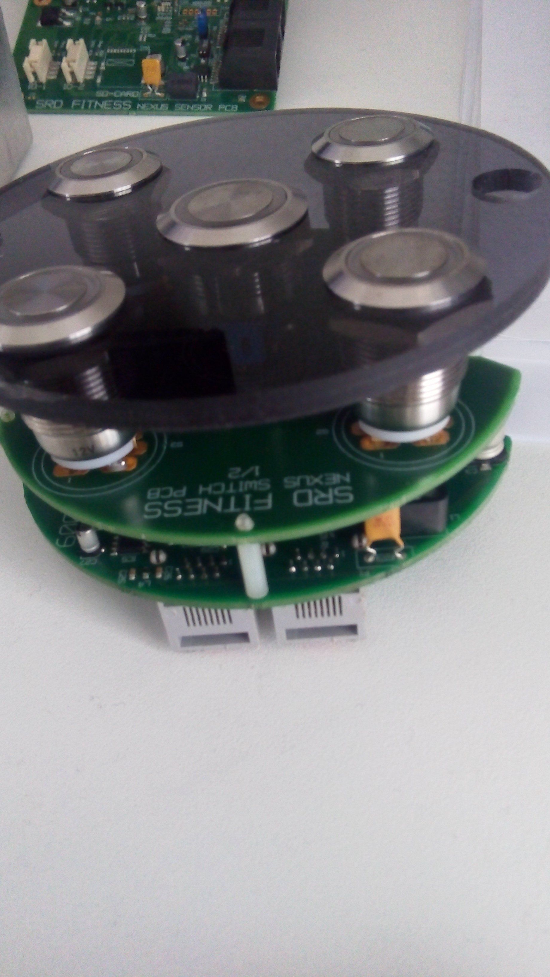 Circular electronic sensor module with black top, green circuit board, and metal standoffs.