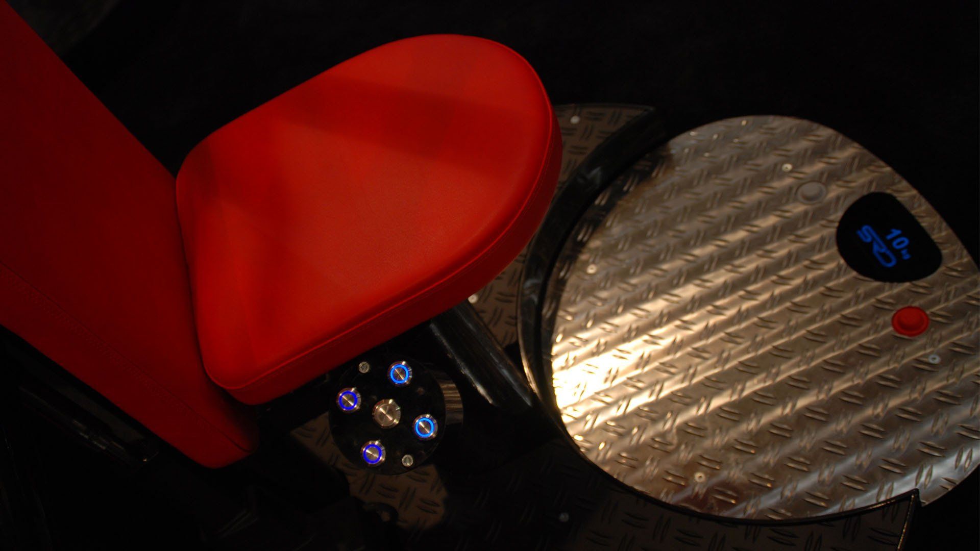 Red heart-shaped case beside a round silver device showing 6%, with small blue lights in the dark