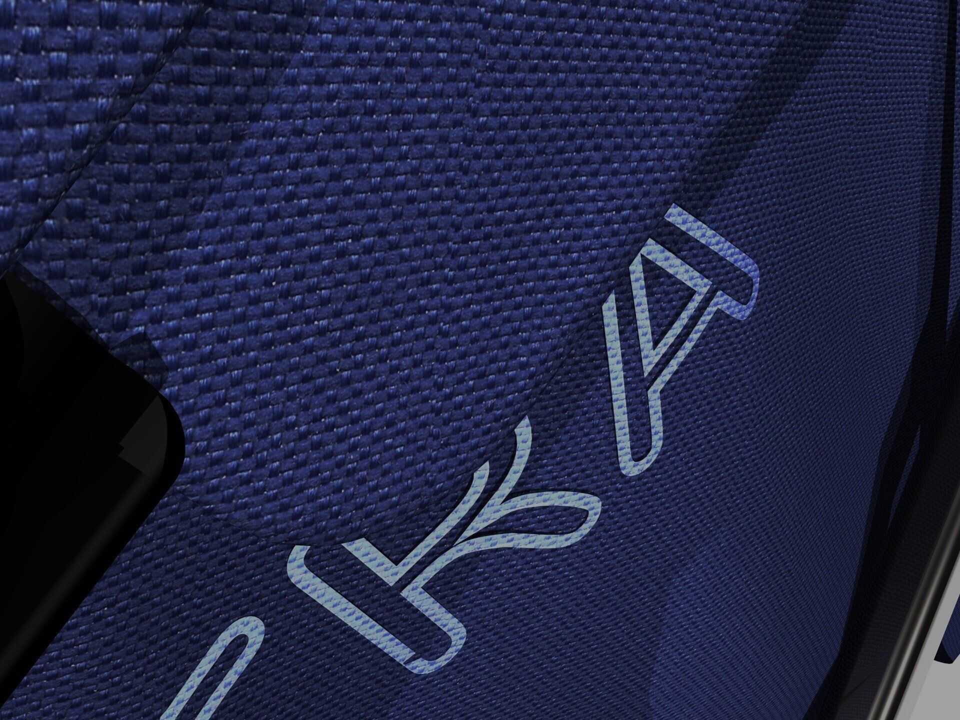 Close-up of blue textured fabric with stitched white lettering partially visible