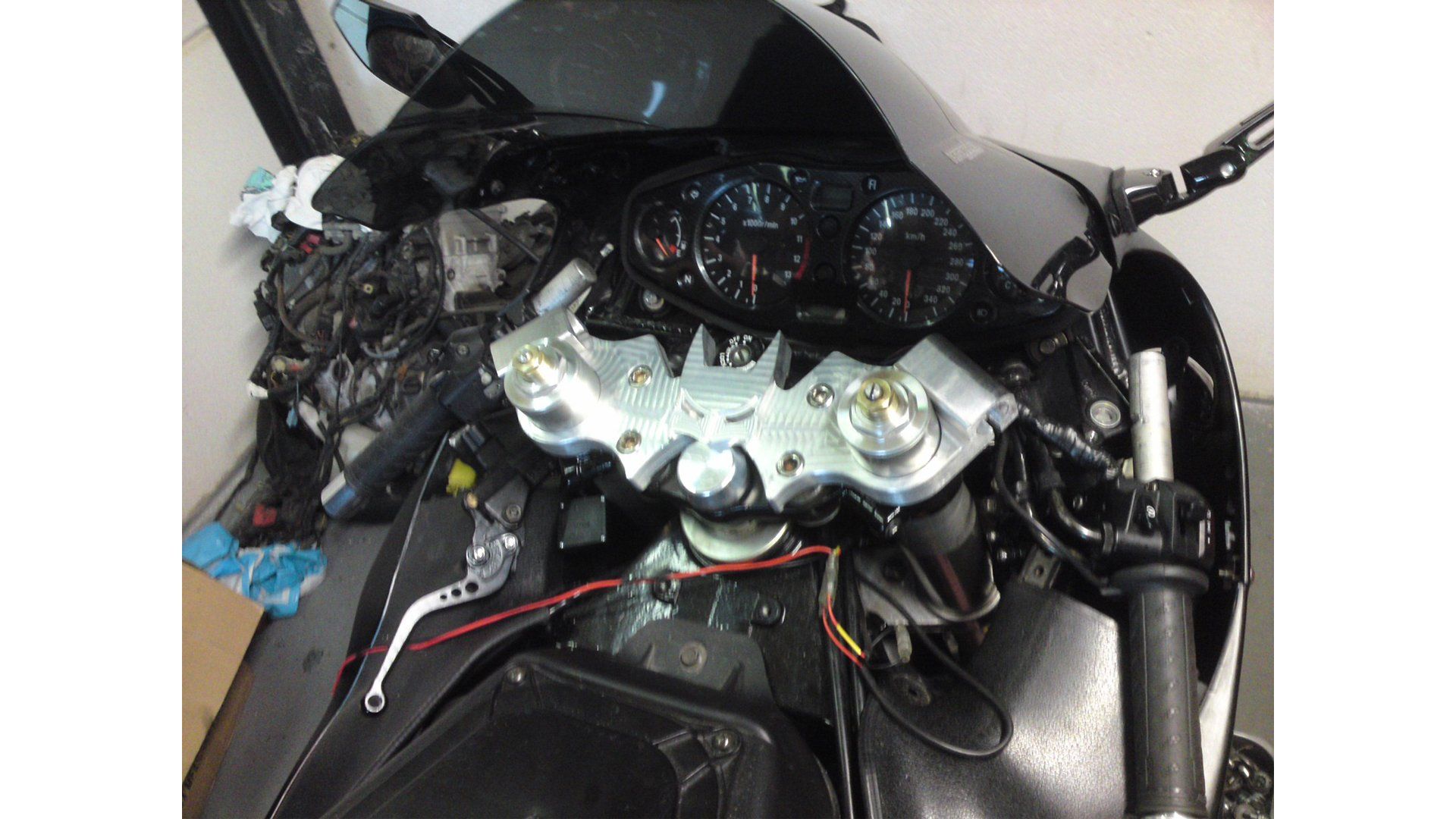 Damaged motorcycle cockpit with exposed wiring and broken front fairing after a crash