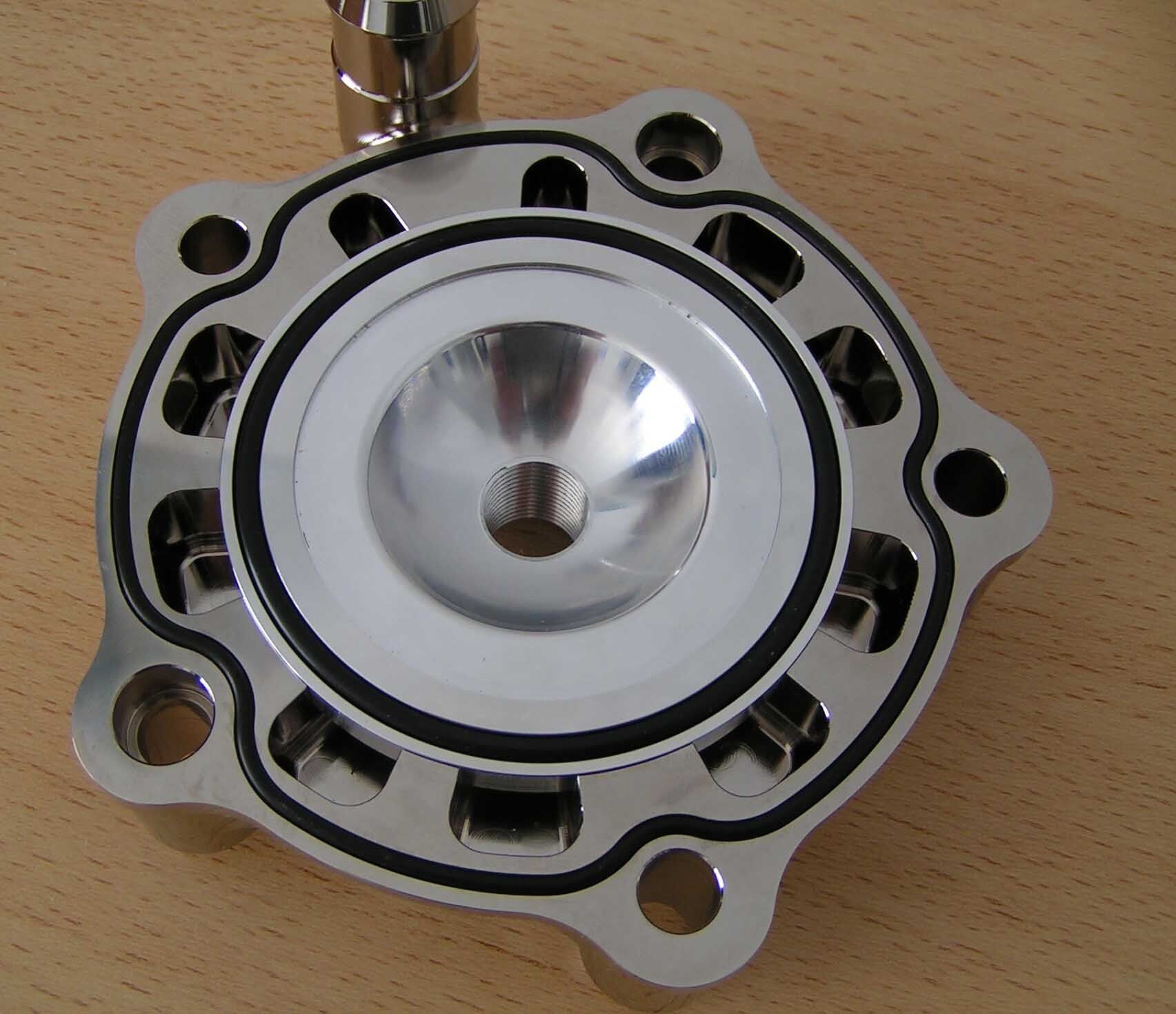 Silver metal speaker cone on a wooden surface, viewed from above.