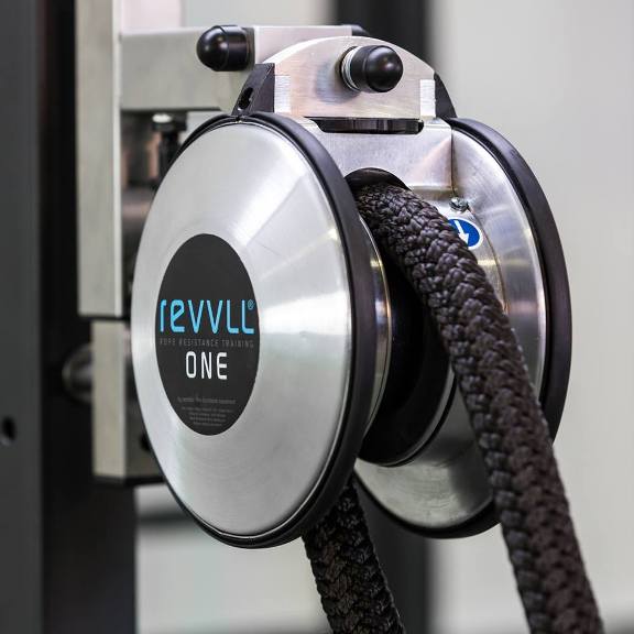 Rewilder ONE wall-mounted cable reel with black braided hose on a metal fixture