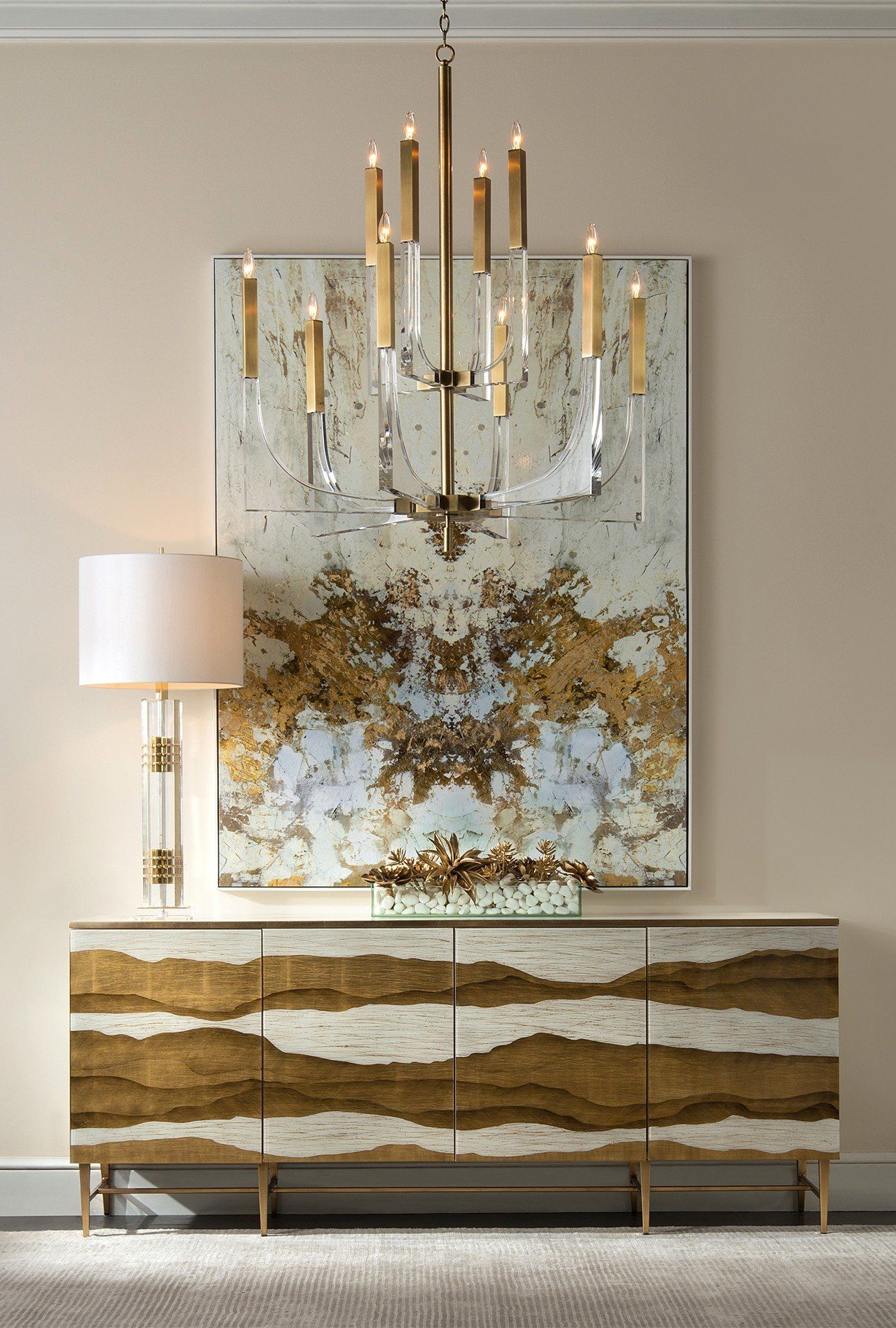 Home lighting including a chandelier and a lamp. Table with a unique design and decorative painting in background